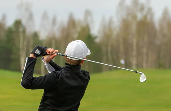 Player during a golf game during a hit