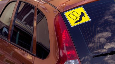 By car sign with a female shoe, which means a woman driving. clipart