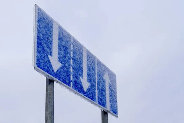 Vägskylt täckt av snö. Svåra vägförhållanden. — Stockfoto