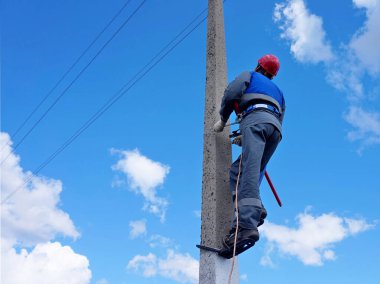 Elektrikçi elektrik direğine tırmanıyor..