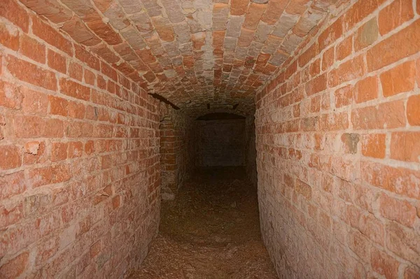 Підземелля. Підземний прохід, тунель, арка викладена червоною цеглою . — стокове фото