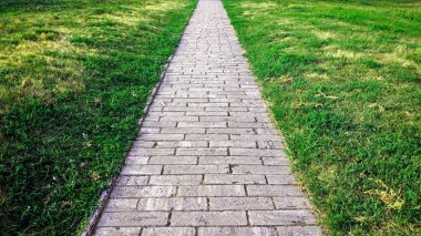 Kaldırımda. Granit gri kaldırım taşından düz bir yol.