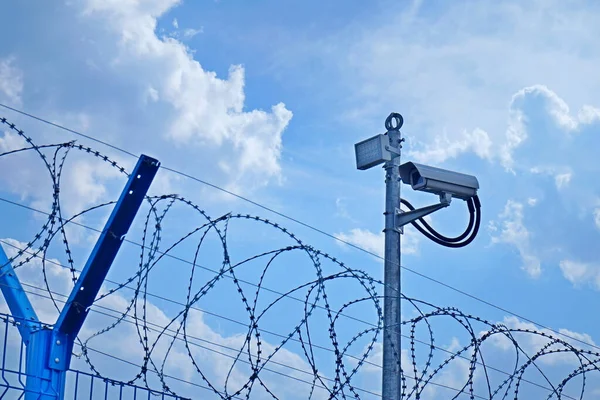 Fence, barbed wire and video camera. — Stock Photo, Image