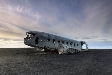 Gün batımında Solheimasandur plajda düşen Dc-3 uçak ile inanılmaz manzara. South Iceland'deki / daki siyah kum plajı üzerinde uçak enkazı.