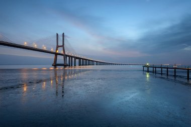 Vasco da Gama Köprüsü manzarası gün doğumunda. Dünyanın en uzun köprülerinden birisidir. Lizbon muhteşem bir turistik yerdir çünkü ışığı, anıtları vardır. Portekiz tarihi.