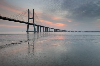 Vasco da Gama Köprüsü manzarası gün doğumunda. Dünyanın en uzun köprülerinden birisidir. Lizbon muhteşem bir turistik yerdir çünkü ışığı, anıtları vardır. Portekiz tarihi.