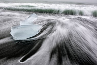 İzlanda'daki muhteşem elmas plaj. Jokulsarlon plajında siyah kumlu plajile buz kaya. Bu ünlü kum lav plaj buzul lagün Jokulsarlon yakın yerleştirilen birçok dev buz taşlar, doludur 