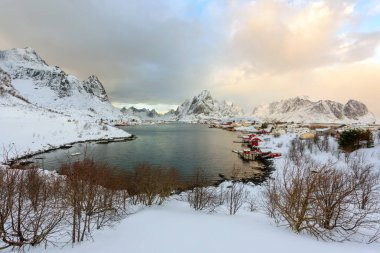 Norveç 'in Lofoten Adaları' ndaki güzel Reine köyü. Kar gün batımında kış manzarasını kapladı. Kutup çevresinde inanılmaz bir turistik cazibe var. Panoramik görünüm.