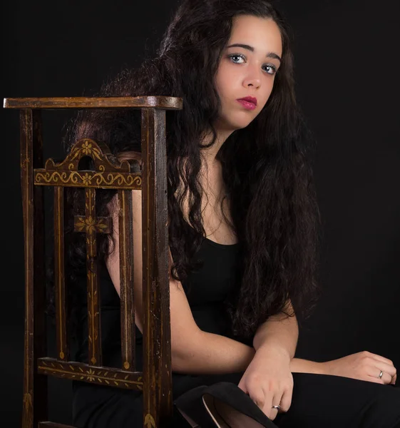 Junge Frau sitzt auf einem alten Stuhl — Stockfoto