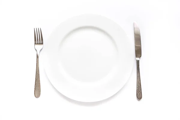 Coltello, forchetta e piatto su fondo bianco — Foto Stock