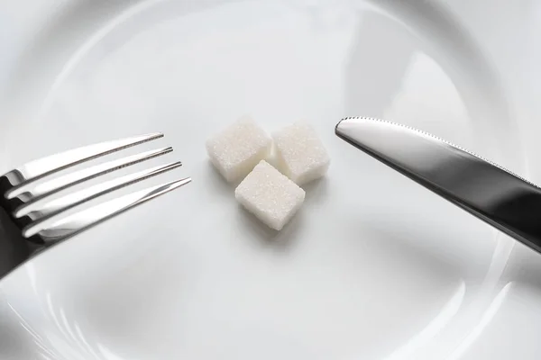 Yukarı Cose bıçak ile plaka üzerinde şeker, beyaz bir arka plan üzerinde çatalı