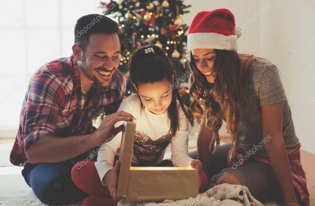 Young family  opening a Christmas present on a Christmas morning