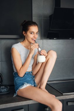 Sevimli genç kız mutfak üst süt içme