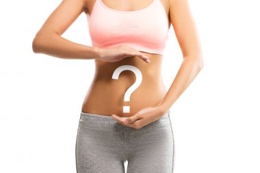 Woman holding a question mark over her abdomen clipart