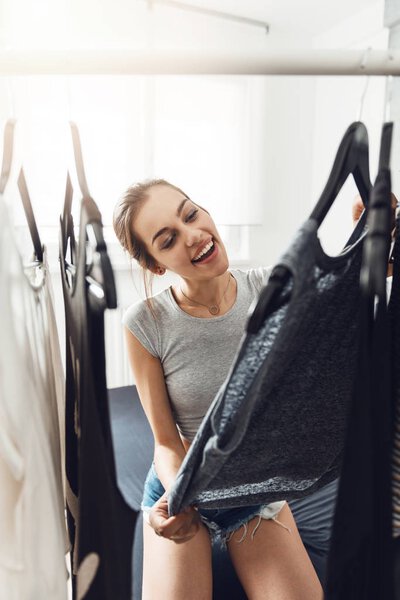 Милая молодая женщина, ищущая, что надеть
