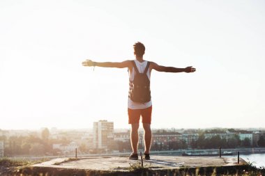 Genç bir şehir manzaralı cliff üzerinde duran adam, silah geniş aç