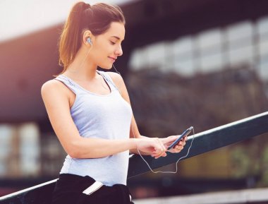 Genç kadın dışında cellphone ile egzersiz bir mola