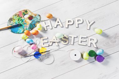 Renkli yumurta ve diğer süslemeler işaretiyle mutlu Paskalya, Paskalya arka plan beyaz ahşap bir masa üzerinde