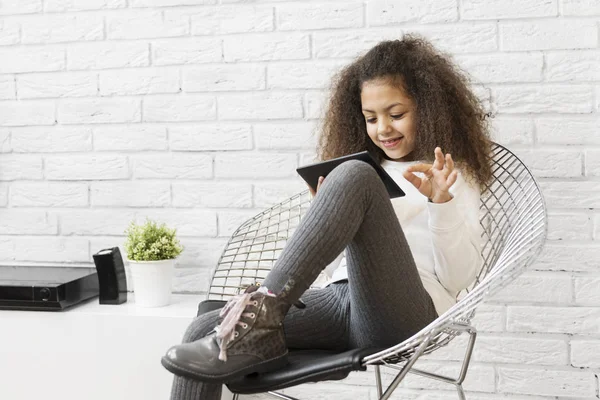 Nettes Mädchen Sitzt Auf Einem Stuhl Und Benutzt Ein Tablet — Stockfoto