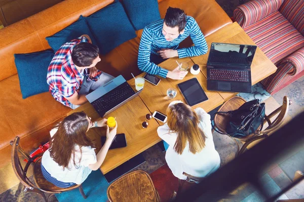 Gençlerin Grup Elektronik Becerikli Alet Tutan Bir Kafede Oturan — Stok fotoğraf