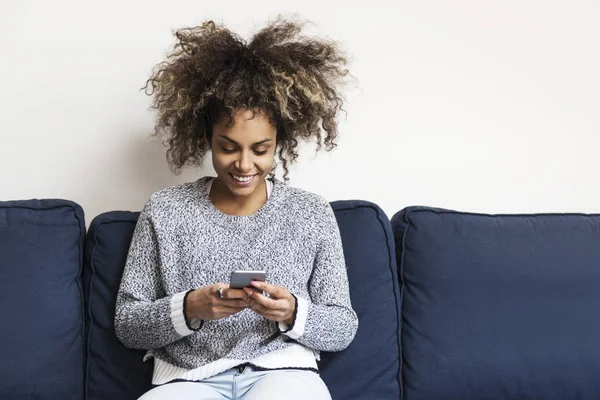 Bella Donna Afroamericana Seduta Sul Divano Con Telefono Cellulare — Foto Stock