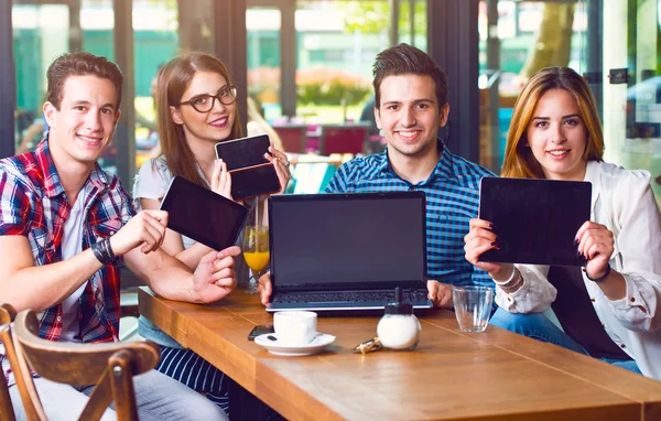 Grupa Młodych Ludzi Siedzi Kawiarni Posiadających Elektroniczny Gadżety — Zdjęcie stockowe