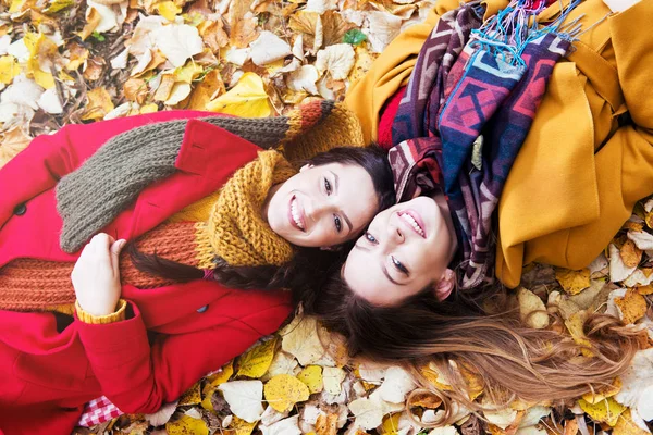 Dos Hermosas Mujeres Jóvenes Acostadas Sobre Hojas Amarillas — Foto de Stock