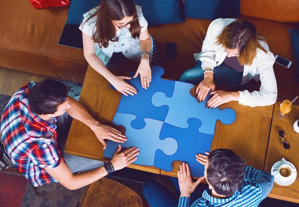 Bir grup insan bir bulmaca parçaları, üstten görünüm tutan bir kafede oturan genç