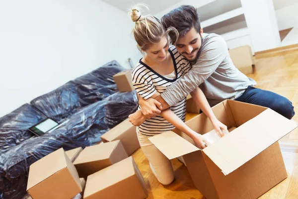 Casal Jovem Movendo Sua Nova Casa Desempacotando Caixas — Fotografia de Stock