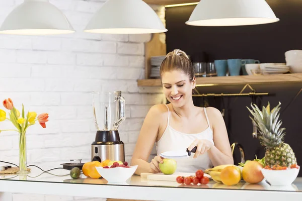 Genç kadın kesme meyve mutfak