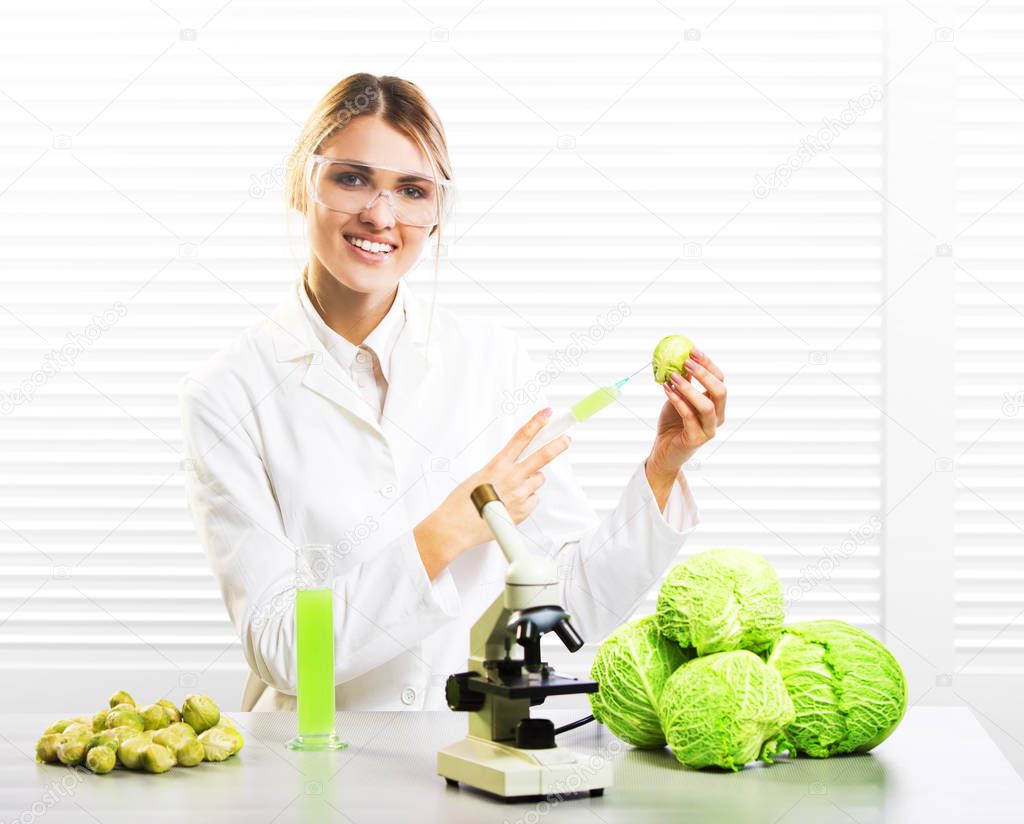 Woman scientist injecting cabbage with synthetic substances for growth; GM food