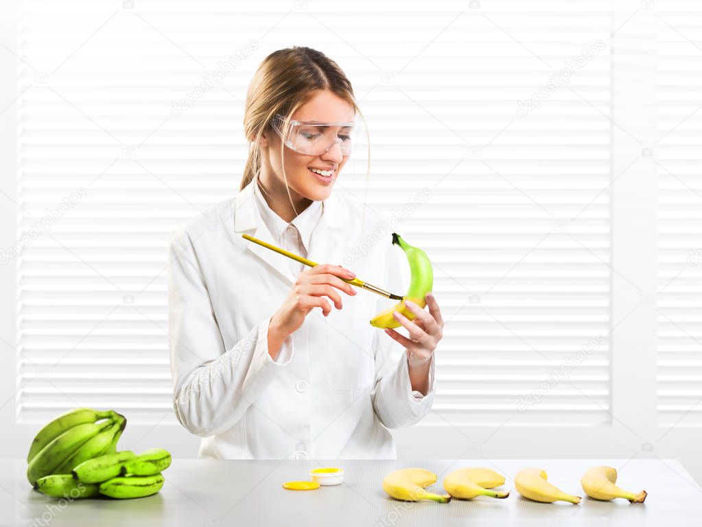 Woman scientist coloring bananas; artificial color; GM food