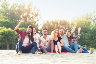 Bir grup genç insan sahilde dışarıda eğleniyor