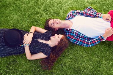 Genç çift çimenlerde dinleniyor.