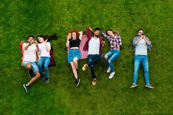 Groep Jongeren Opleggen Aan Het Gras Cirkel Met Behulp Van — Stockfoto