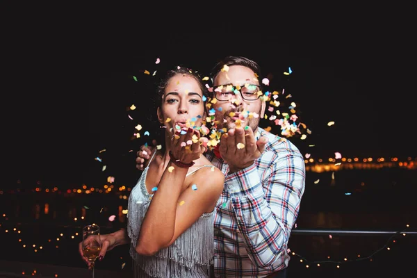 Bonito Jovem Casal Soprando Confete — Fotografia de Stock