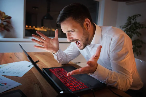 Businessman working on a laptop, overworking, under pressure