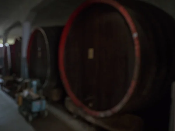 Wijnvaten gestapeld in de oude kelder van de wijnmakerij. — Stockfoto