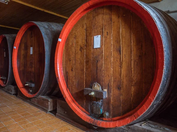 Wine barrels stacked in the old cellar of the winery. — Stock Photo, Image
