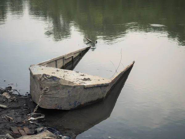 Nehir kıyısında bir eski halfsunken balıkçı teknesi.