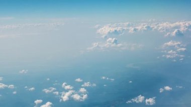 Mavi gökyüzü ile beyaz bulutlar. Bulutlar ve arazi bir uçak penceresinden görünümü
