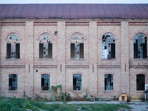 Fachada frontal de um edifício abandonado com janelas quebradas . — Fotografia de Stock