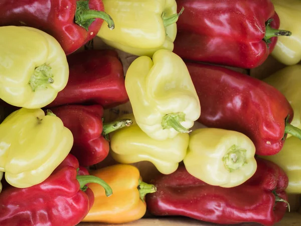 Backdrop of stacked large, sweet, red and yellow peppers.