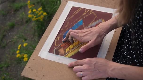 The girl draws with pastel crayon. Drawing on the board. — Stock Video