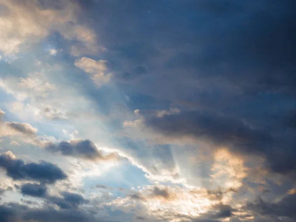 Céu por do sol com nuvens escuras e brancas refletindo raios de sol . — Fotografia de Stock