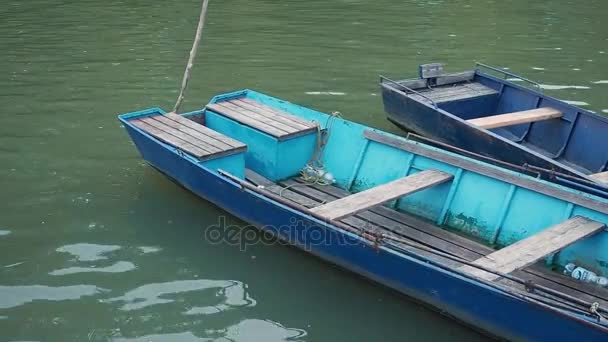 Oude roeien-vissersboten op de pier op het water. — Stockvideo
