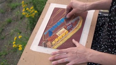 Kız pastel boya ile çizer. Tahtada çizim.