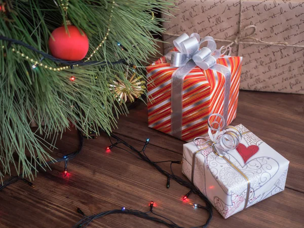 Albero di Natale verde decorato con giocattoli e ghirlanda led luci. Scatole regali — Foto Stock