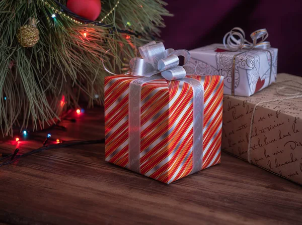 Πράσινο χριστουγεννιάτικο δέντρο διακοσμημένο με παιχνίδια και γιρλάντα led φώτα. Κουτιά δώρων — Φωτογραφία Αρχείου