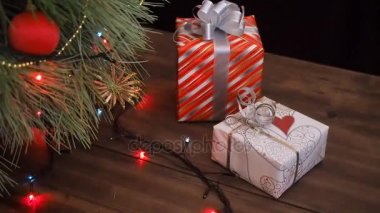Hediye kutuları ağacın altında bulunmaktadır. Hediyeler renkli kağıt Paketli ve dize ve kurdele ile bağlanmış. Noel çelenk köknar ağacı dalları üzerinde. Ağaç dallarının yakın, vardiya hareket, panorama